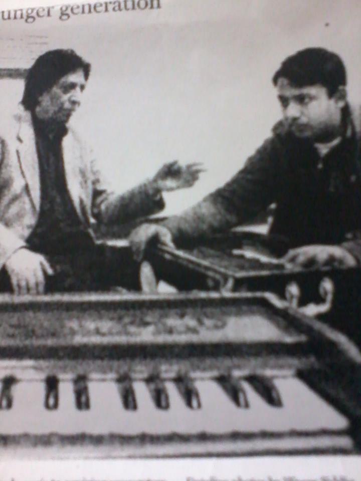 a picture of Faraz Qadir with legend Ustad Bade Fateh Ali Khan teaching him a music lesson in early days.